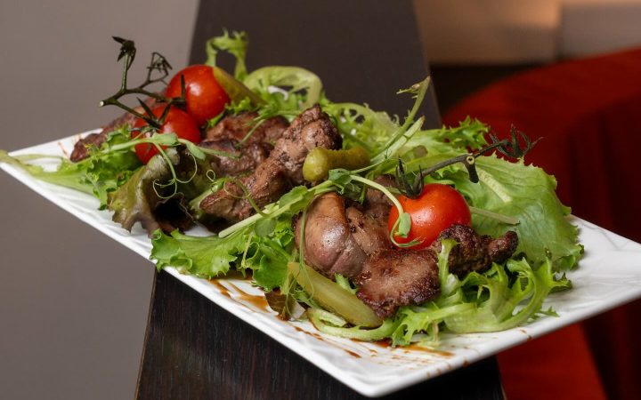 Une assiette de viande grillée accompagnée d'une salade de laitue et de tomates