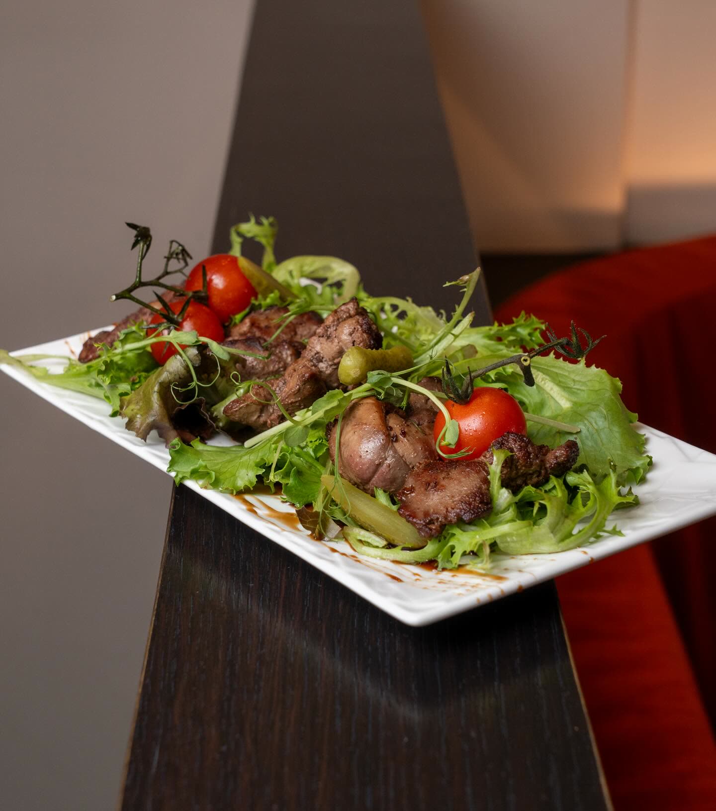 Une assiette de viande grillée accompagnée d'une salade de laitue et de tomates