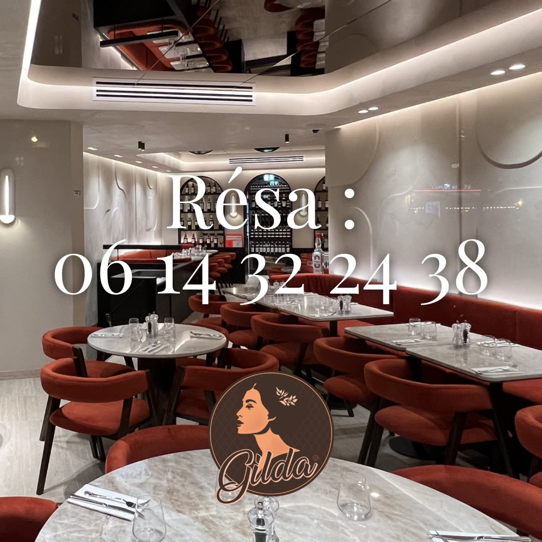 L'intérieur d'un restaurant avec des tables dressées et des banquettes rouges