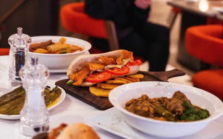 Une table dressée avec plusieurs plats de cuisine tunisienne et des salières