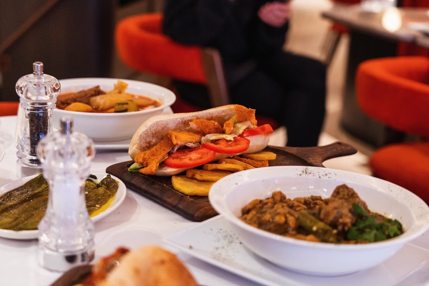 Une table dressée avec plusieurs plats de cuisine tunisienne et des salières