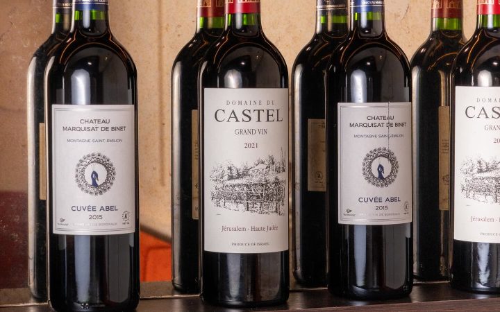 Plusieurs bouteilles de vin rouge sont alignées sur une étagère dans un restaurant